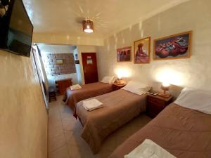 a hotel room with two beds and a television at Hosteria Maimará in Maimará