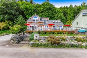 a large house with a large deck with red umbrellas at Tyee Legacy in Tyee Beach