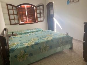 a bedroom with a bed with a blue comforter at Chácara Cantinho que Deus me Deu in Sao Paulo +38 photos