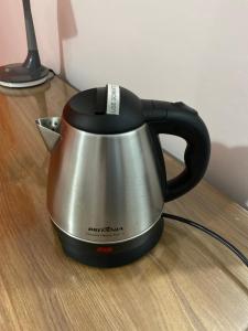 a black and silver tea kettle on a wooden table at Bougainville - Hotel Pousada-Zen in Salvador