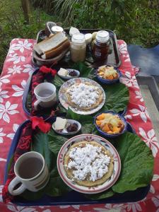 einen Tisch mit Teller mit Lebensmitteln auf einem Tisch in der Unterkunft Royal Authenticité in Patio