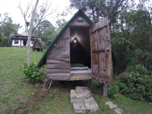 a small wooden dog house in a yard at Gran Camping Cabanas da Fazenda in Visconde De Maua