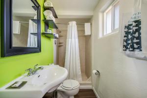 a bathroom with a white sink and a toilet at Signature Inn Eugene in Eugene +37 photos