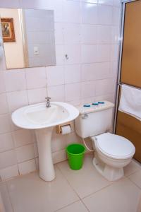 a bathroom with a sink and a toilet at Central Park Hotel Residence in São Carlos