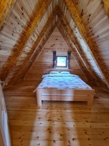 - une chambre avec un lit dans un grenier en bois dans l'établissement Original Wooden Lodge 2, à Žabljak