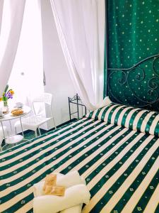 een slaapkamer met een groen en wit gestreept bed bij Big Fish Alghero Guesthouse in Alghero