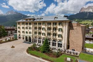 an aerial view of a building with mountains in the background at Grand Hotel Savoia Cortina d'Ampezzo, A Radisson Collection Hotel in Cortina dʼAmpezzo