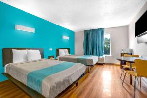 a hotel room with two beds and a table at Motel 6-Raleigh, NC - North in Raleigh