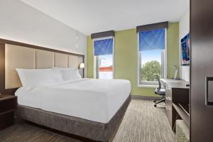 Cama grande en habitación con escritorio y ventanas en Hotel 1200, en Brooklyn