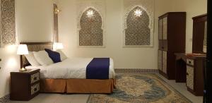 Un dormitorio con una cama y dos ventanas. en Nuzul Altoot Apartments نزل التوت, en Riad