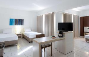 Uma TV ou centro de entretenimento em Best Western Suites Le Jardin Caldas Novas