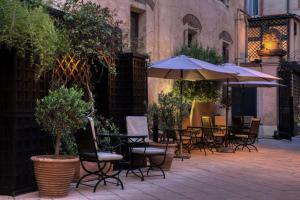 an outdoor patio with tables and chairs and an umbrella at Grand Hotel de l'Opera - BW Premier Collection in Toulouse