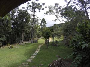 a path through a field of grass with trees at Gran Camping Cabanas da Fazenda in Visconde De Maua