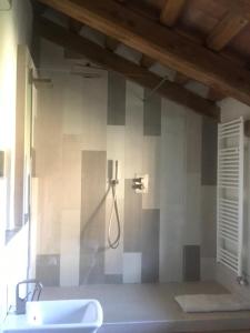een badkamer met een bad, een wastafel en een douche bij La locanda del cuore in Carrù