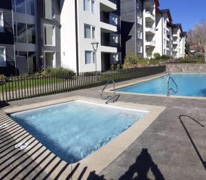 a swimming pool in front of a apartment building at Departamento en Pucón in Pucón