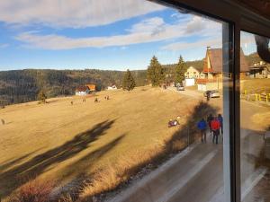 a group of people walking in a field from a window at Morehead Guesthouse Vlasic in Vlasic