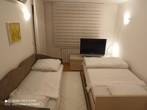 a small room with two beds and a television at Zagreb LAKE STAR & Included garage parking place in Zagreb