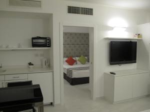 een kamer met een slaapkamer met een bed en een televisie bij Best Western Regency Suites in Tel Aviv