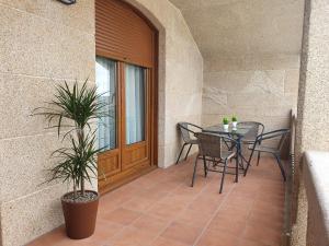 patio con mesa, sillas y ventana en Apartamento A casa da feira, en Pontevedra