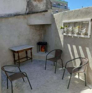 d'une terrasse avec des chaises, une table et une cheminée. dans l'établissement Caldas Relax & Leisure, à Caldas da Rainha