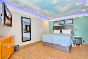 a bedroom with a bed and a tv in it at Mid City Inn in Los Angeles +12 photos