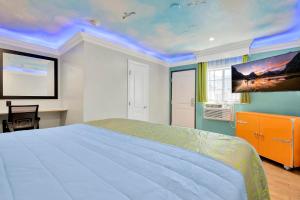 1 dormitorio con 1 cama y una pintura en el techo en Mid City Inn, en Los Ángeles