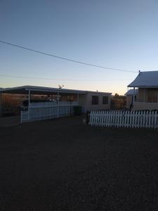 a house with a white fence and a building at Mountain view efficiency in Tombstone