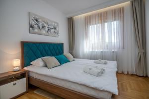 a bedroom with a large bed with two towels on it at Bora Bora Apartmani Zlatibor in Zlatibor