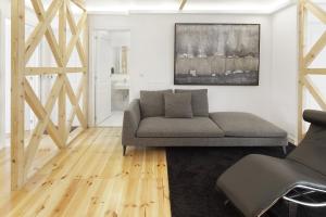 una sala de estar con un sofá y una silla en Room Lusíadas with private bathroom, en Lisboa