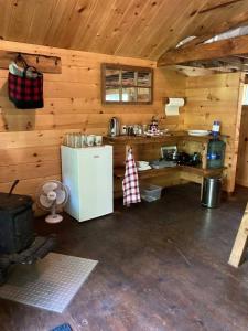 a kitchen in a wooden cabin with a refrigerator at Les Cabines Nordik 2.0 in Shawinigan