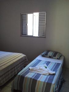 two beds in a room with a shirt on the bed at Casa na praia do Jabaquara in Paraty