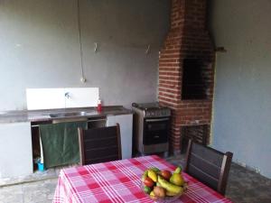 a kitchen with a table with a bowl of fruit on it at Casa na praia do Jabaquara in Paraty +9 photos
