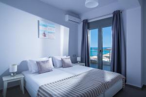 a bedroom with a bed with a view of the ocean at Coast Suite-Luxury Central Beach House in Hersonissos
