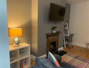 a living room with a couch and a tv and a fireplace at Gateshead Serviced Apartment Ideal for Contractors and Vacationing in Gateshead