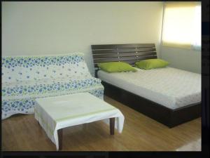 a room with two beds and a bench in it at Room in Apartment - Poppular Palace Don Mueang Bangkok, 5-minute drive from Impact Arena in Ban Bang Phang