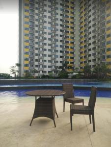 a table and two chairs and a table and chairs at Apartemen Springlake Summarecon Bekasi-By Bu Johan in Bekasi +19 photos