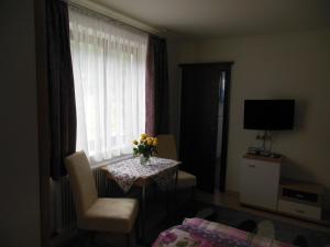 a room with a table with a vase of flowers and a window at Ferienhaus Moser in Bad Gastein