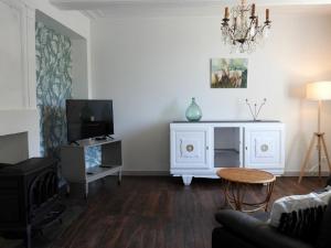 ein Wohnzimmer mit einem Sofa und einem TV in der Unterkunft Gîte Dommartin-le-Franc, 3 pièces, 4 personnes - FR-1-611-64 