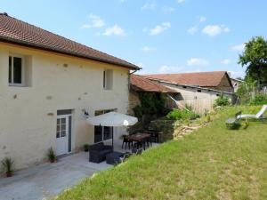 einen externen Blick auf ein Haus mit einem Tisch und einem Regenschirm in der Unterkunft Gîte Dommartin-le-Franc, 4 pièces, 6 personnes - FR-1-611-63 