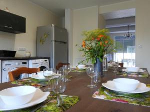 a dining room table with plates and glasses and flowers at Gîte Dommartin-le-Franc, 4 pièces, 6 personnes - FR-1-611-63 