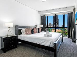 ein Schlafzimmer mit einem großen Bett und einem großen Fenster in der Unterkunft Exceptional Value - 3 BR Apartment - Sierra Grand in Gold Coast