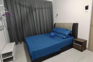 una camera da letto con un letto con cuscini blu e una finestra di Pangsapuri Ladang Tanjung a Kuala Terengganu