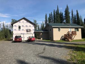 a house and two cars parked in a parking lot at Copperville B & B in Glennallen