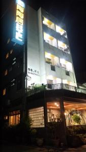 un edificio con un cartel delante de él por la noche en 陶陶居商旅 Tautauchu Hotel en Hualien