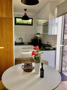 Una mesa con una botella de cerveza y flores. en Refúgio de Pedra, en Fajã da Ovelha