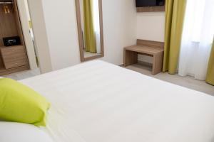 a white bed in a room with a mirror at Casa Marino in Sorrento