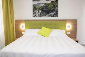 a bedroom with a white bed with a yellow pillow at Casa Marino in Sorrento