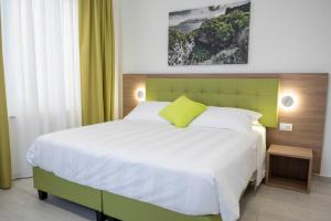 a bedroom with a large bed with a green headboard at Casa Marino in Sorrento