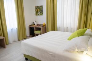 a bedroom with a large white bed and a desk at Casa Marino in Sorrento