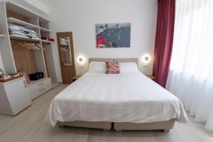 a bedroom with a large white bed and curtains at Casa Marino in Sorrento